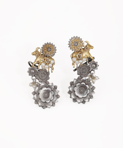 Oxidized silver-tone and gold-tone drop earrings with bull motif, floral elements, and faux pearls.