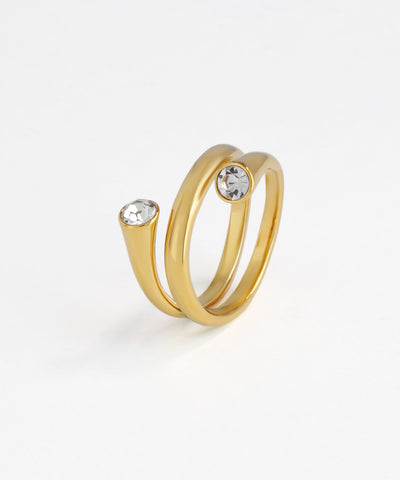 Gold-tone bypass ring with two round clear stones at open ends on white background