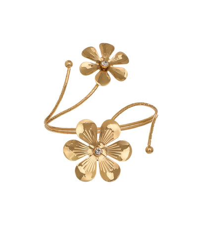 Gold-tone arm cuff with two sculpted floral designs, each featuring a small clear stone center, on a winding textured band.