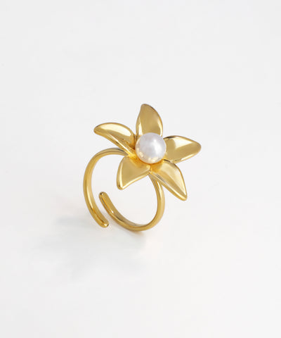 Gold-tone ring with sculpted five-petal flower design and a central faux pearl, open adjustable band.