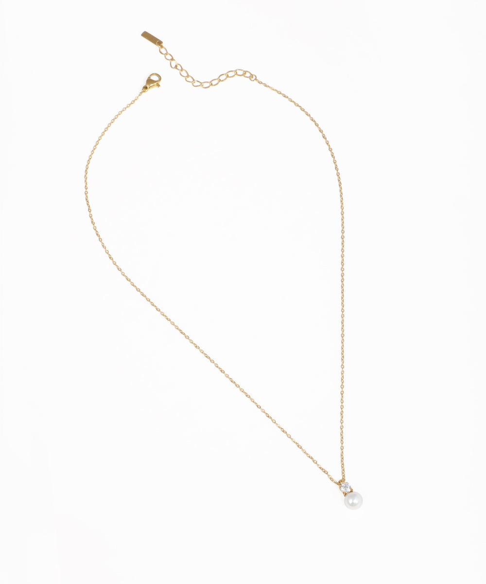 Gold-tone necklace with a small faux pearl and clear CZ stone pendant