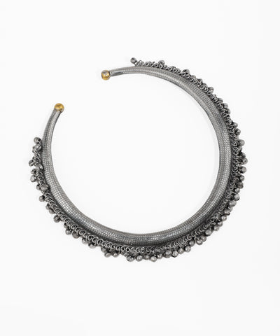 Oxidized hasli necklace with textured surface and multiple rows of small metal ghungroo beads.