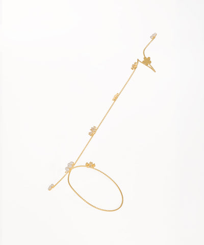 Gold-tone hand cuffs with floral charms, clear stones, and faux pearls