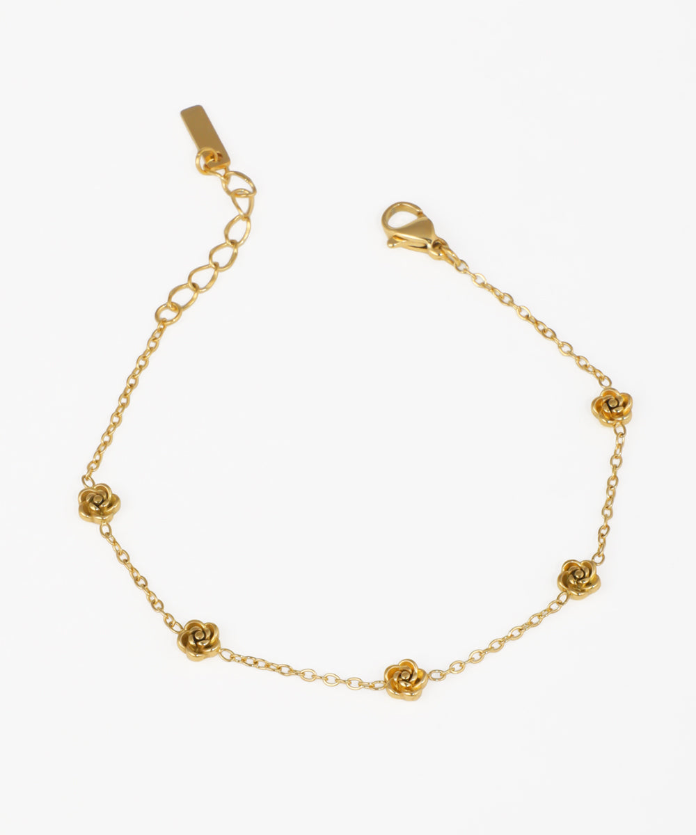 Gold-tone bracelet with delicate rose motifs on a chain with extender