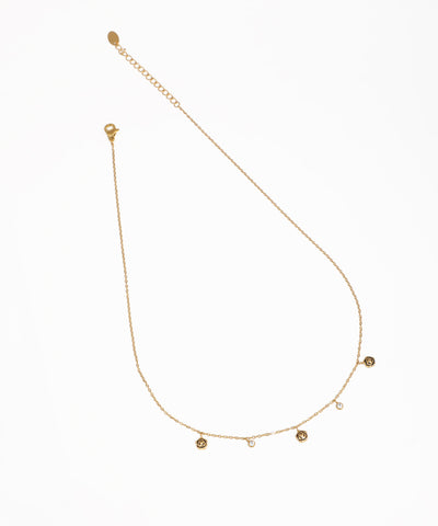 Gold-tone necklace with alternating small medallion charms and bezel-set clear stones on a delicate chain