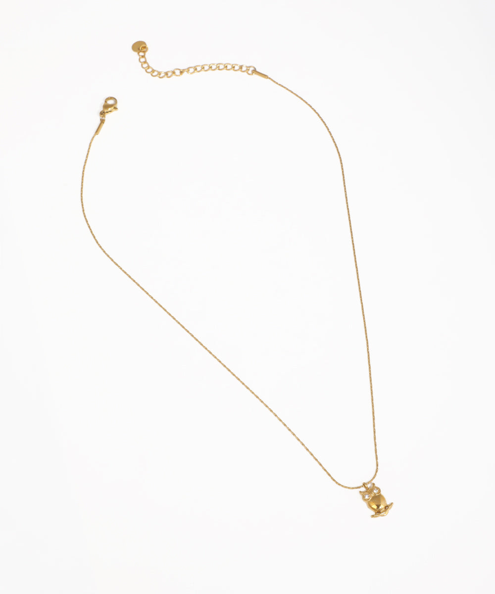 Gold-tone necklace with a small owl pendant and clear stone eyes
