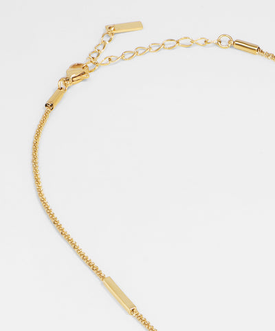Gold bracelet on a light gray background