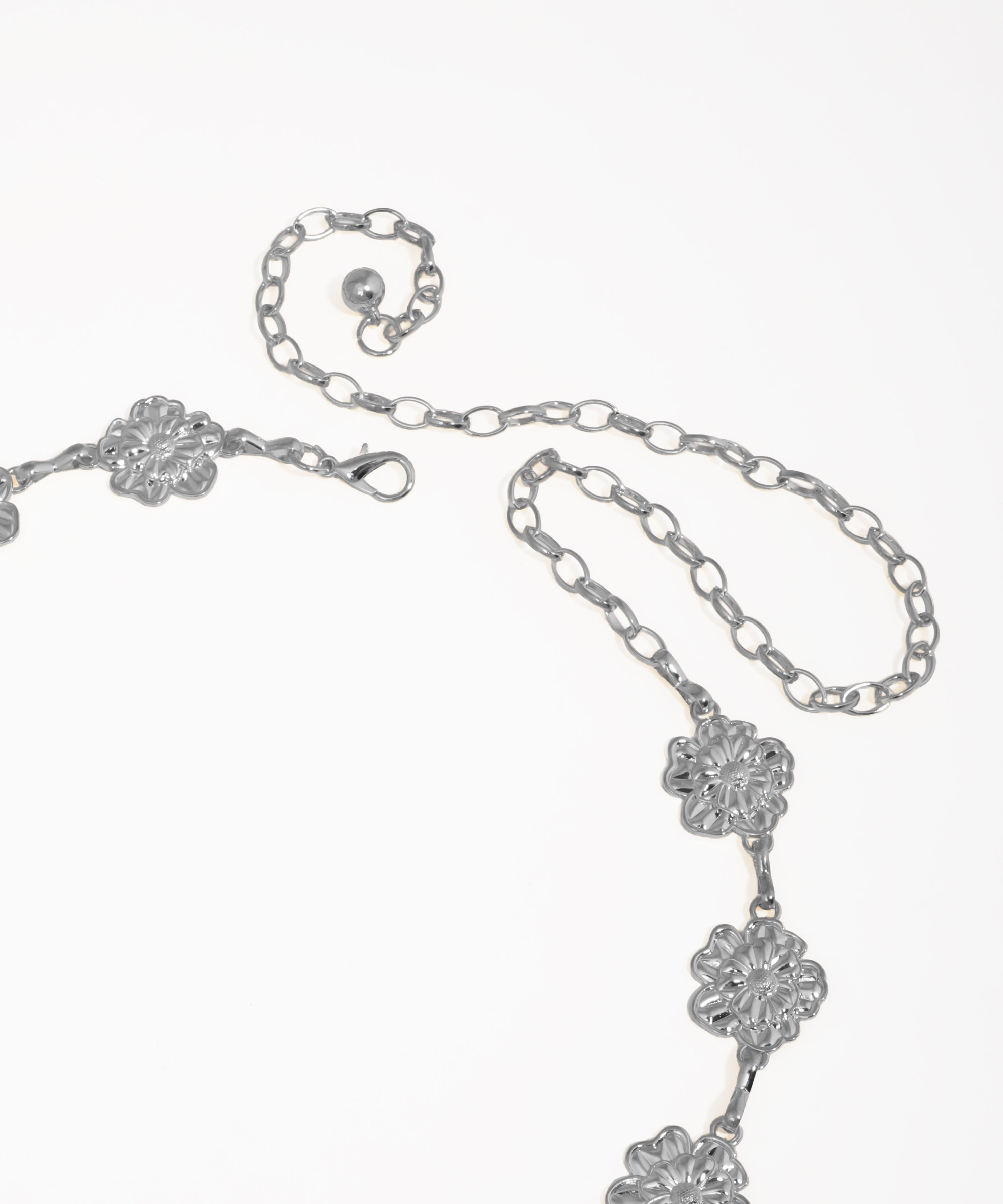 Silver necklace with floral designs on a white background