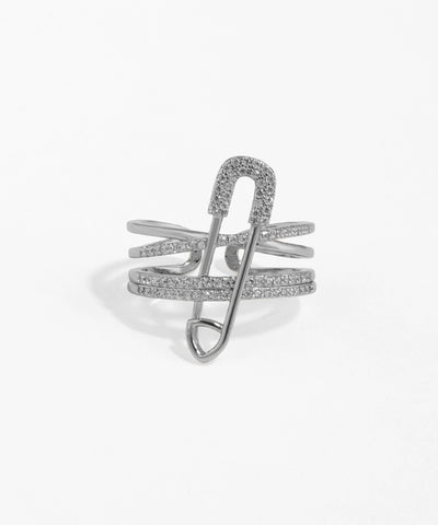 Silver safety pin-shaped ring with clear stones on a white background