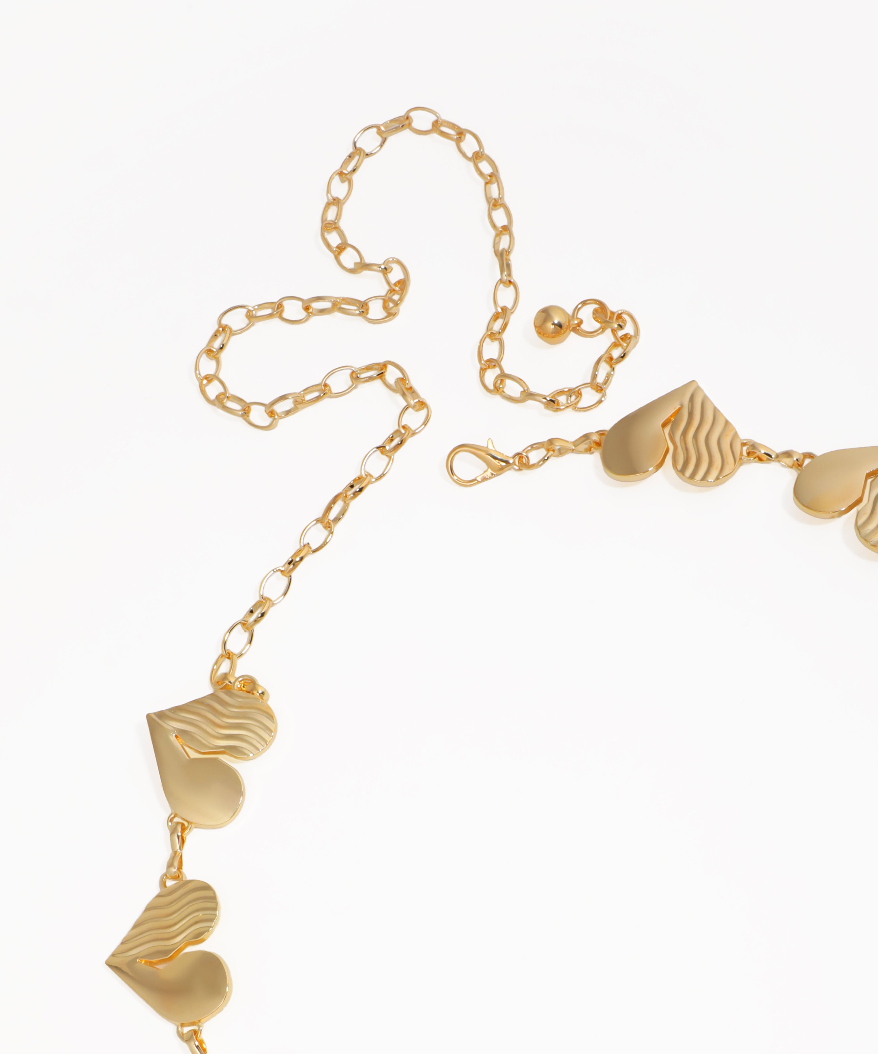 Gold necklace with heart-shaped pendants on a white background