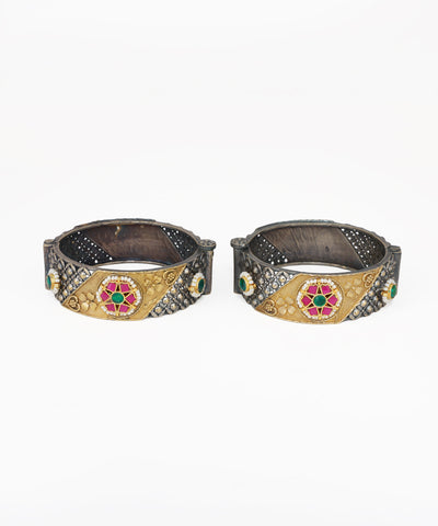 Oxidised silver-tone bangle bracelet with gold-tone accents, red and green stones, and faux pearls