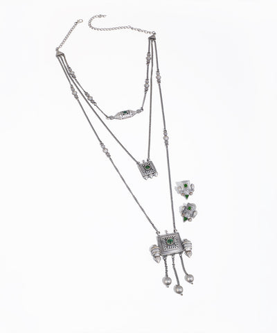 Silver necklace and earrings set on a white background