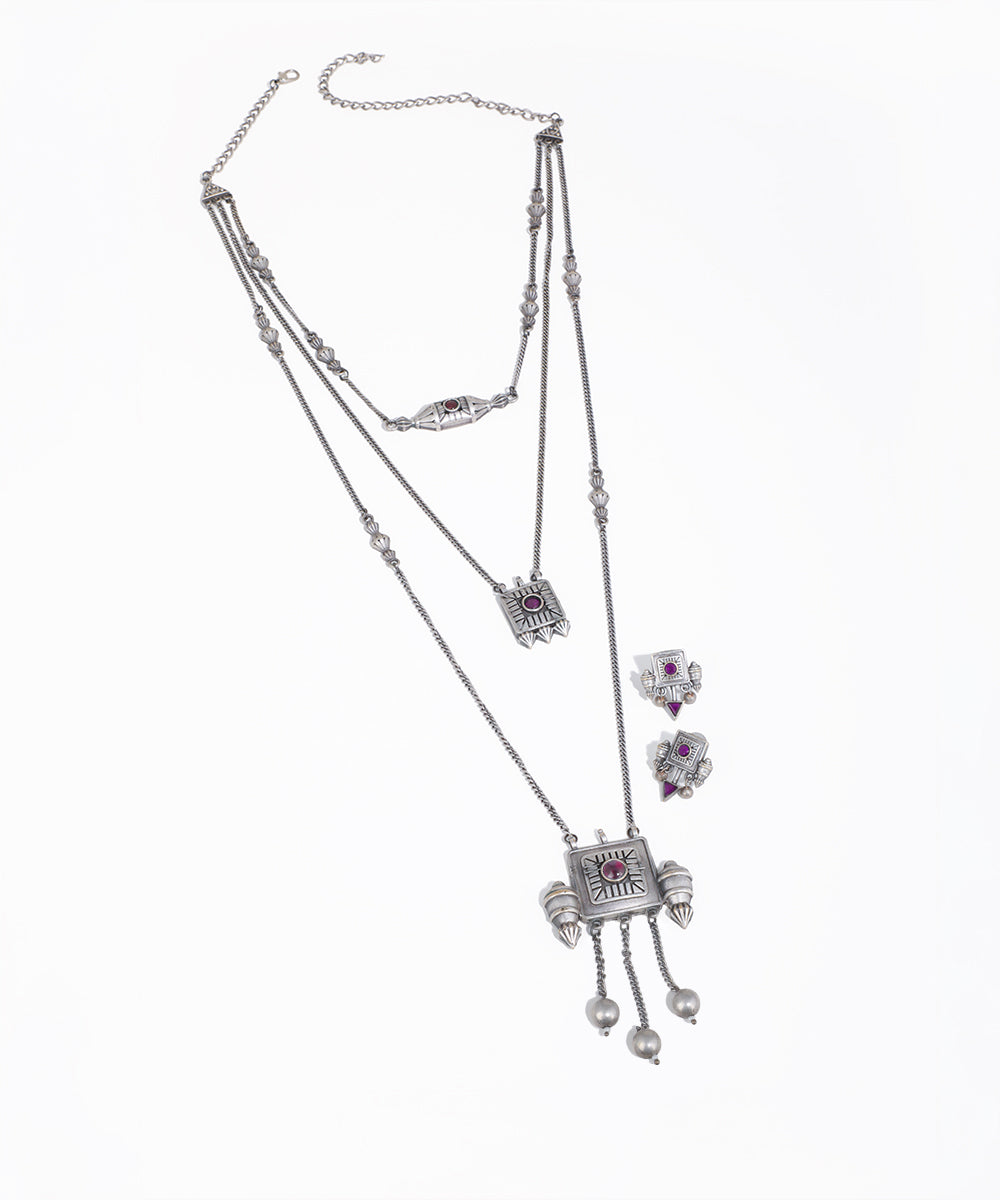 Silver necklace with pendant and matching earrings on a white background