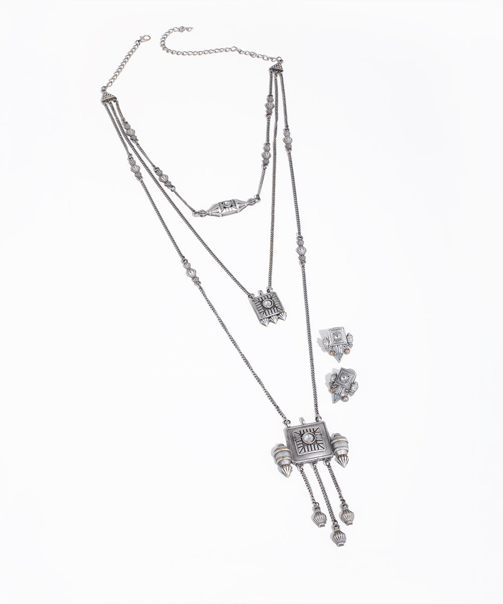 Silver necklace and earrings set on a white background