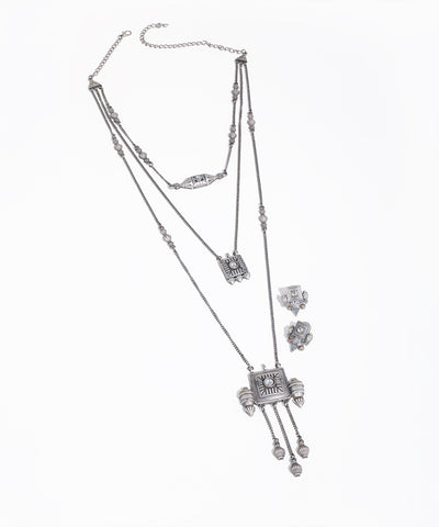 Silver necklace and earrings set on a white background