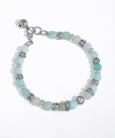 Silver-tone beaded bracelet with aqua, mint, and pale green glass beads, featuring ornate spacer beads and a bell charm.