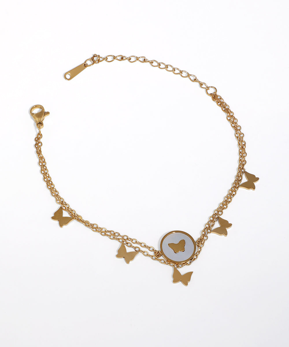 Gold-tone dual chain bracelet with multiple butterfly charms and a central faux pearl butterfly inlay.