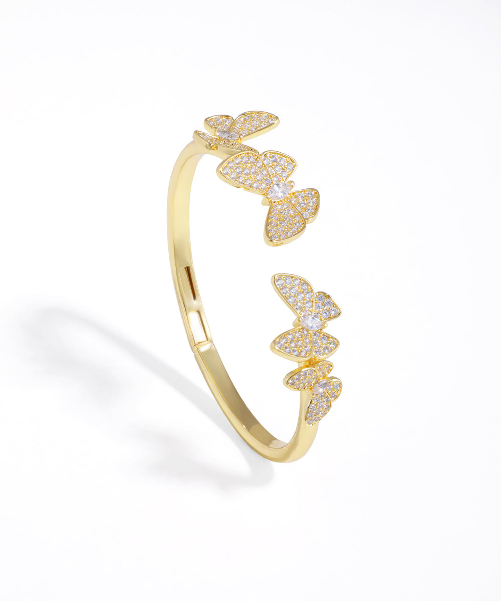 Gold-tone open cuff bracelet with embellished butterfly clusters