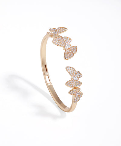 Rose gold open ring with butterfly designs on a white background