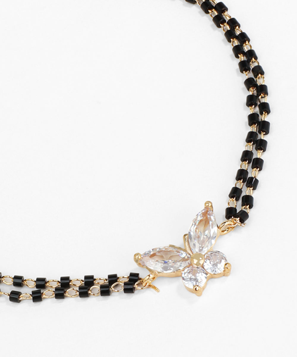 Black beaded necklace with a clear crystal pendant on a white background