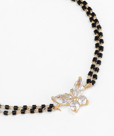 Black beaded necklace with a clear crystal pendant on a white background