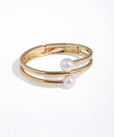 Gold bracelet with pearl accents on a white background