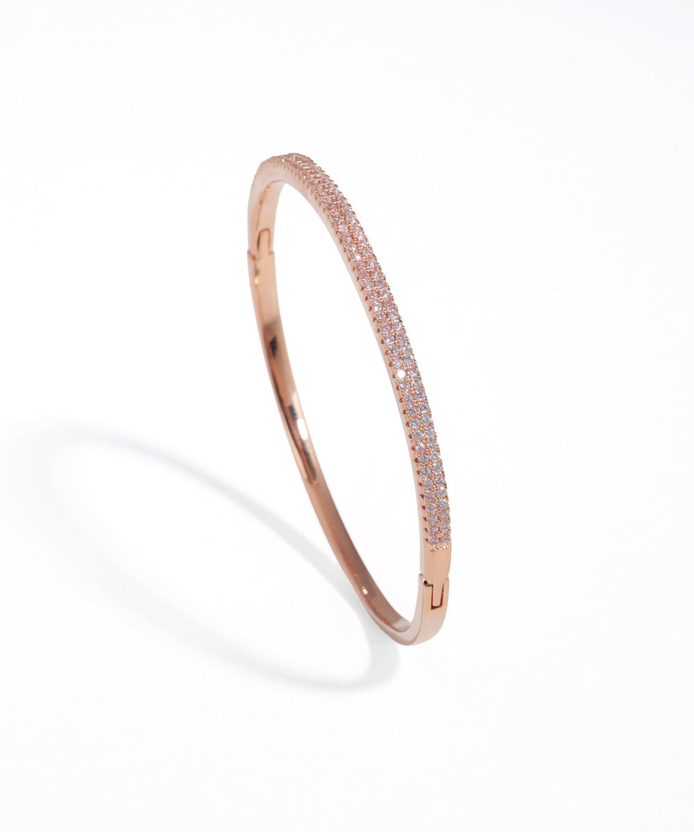 Rose gold bracelet with small stones on a white background