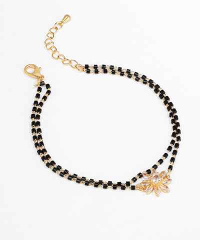 Black beaded bracelet with gold accents on a white background