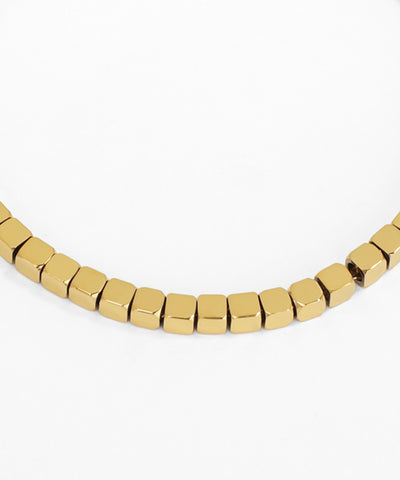 Gold beaded necklace on a white background