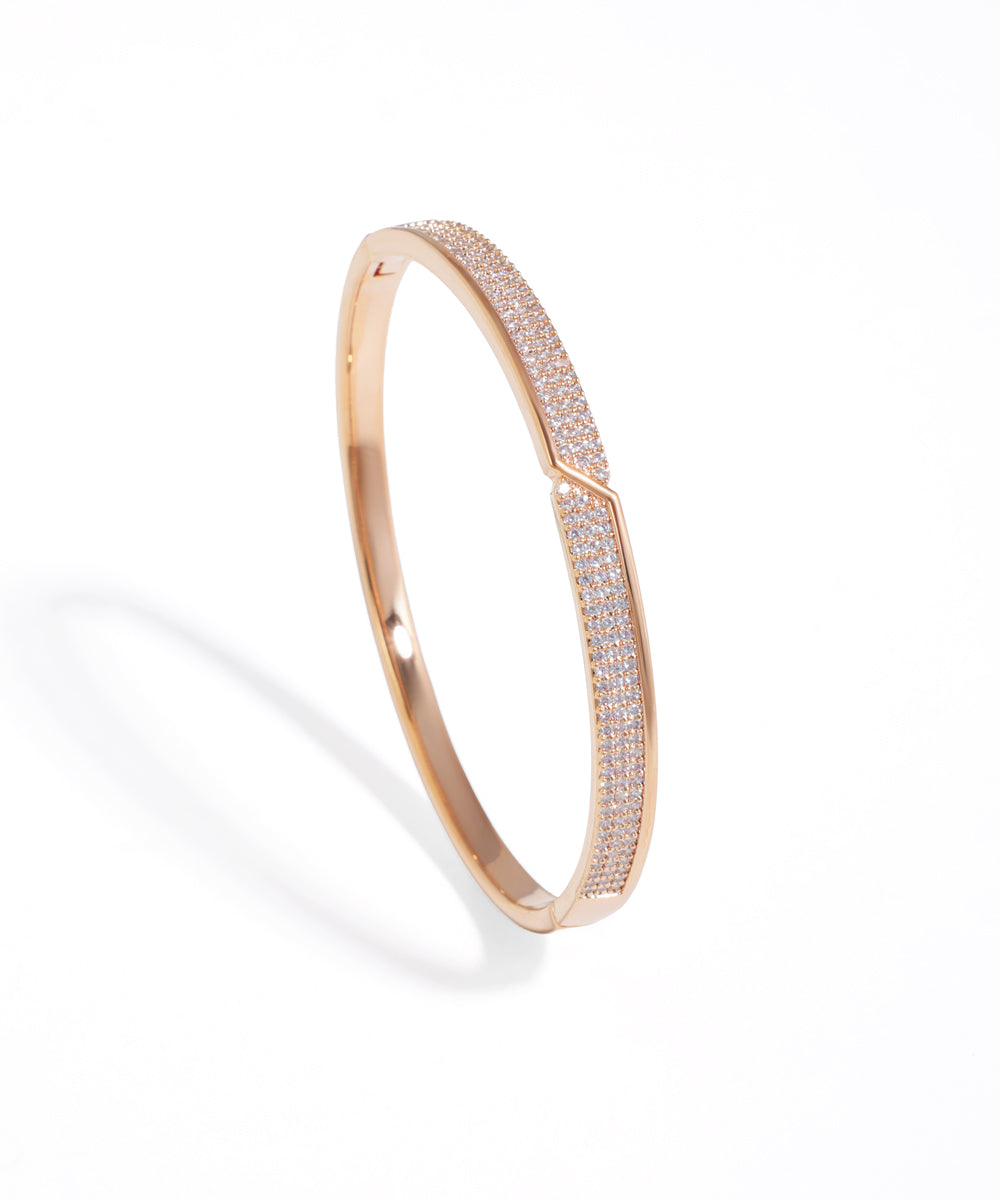 Rose gold bracelet with diamond accents on a white background