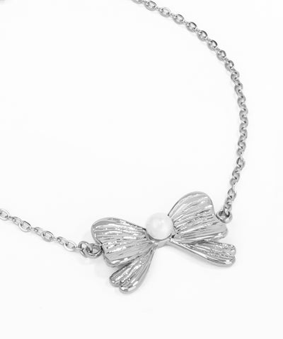 Silver bow-shaped pendant on a chain against a white background