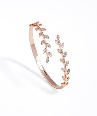 Rose gold bracelet with leaf design on a white background