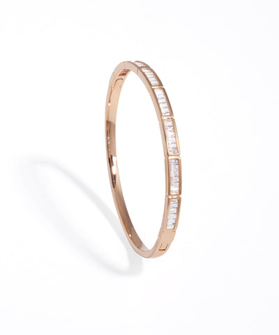 Rose gold bangle with embedded diamonds on a white background
