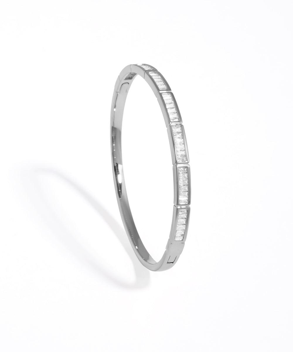 Silver bangle with small stones on a white background
