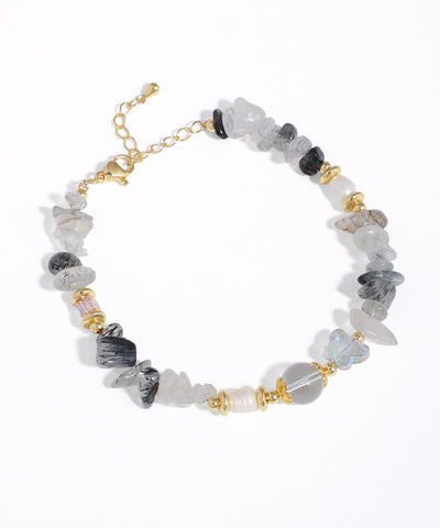 Gold-tone bracelet with grey, black, and clear irregular stone beads, faux pearls, and glass crystals.