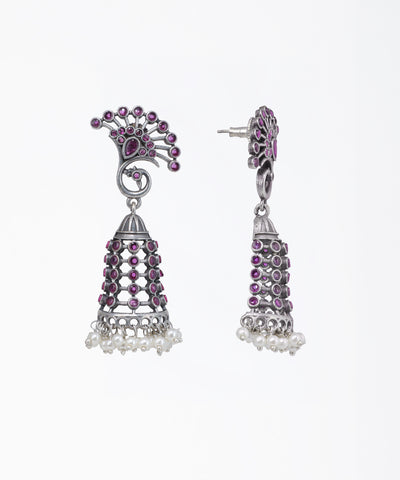 Pair of silver earrings with pink gemstones on a white background