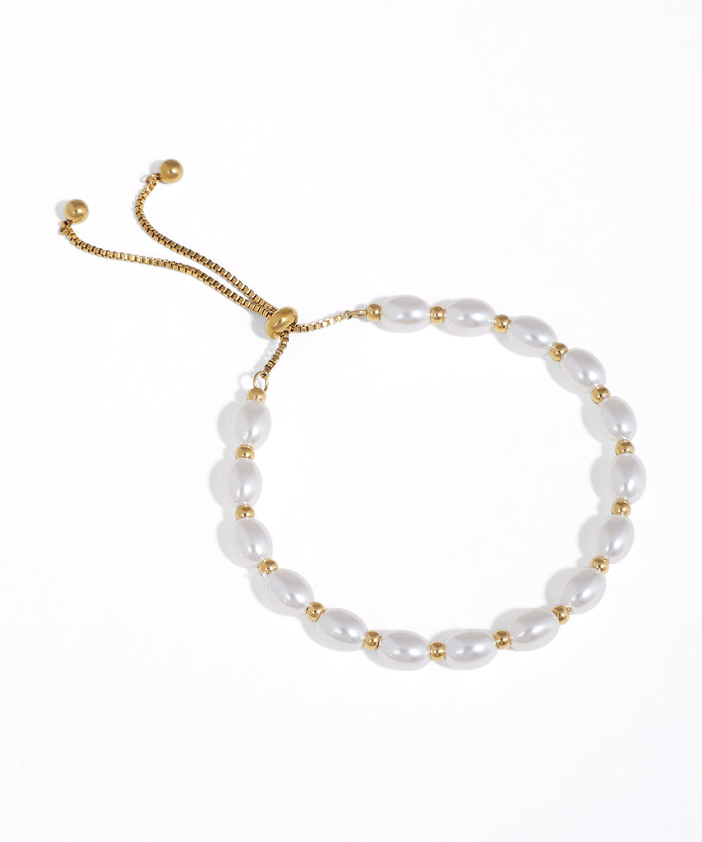 Gold-tone bracelet with oval faux pearl beads and a box chain slider closure