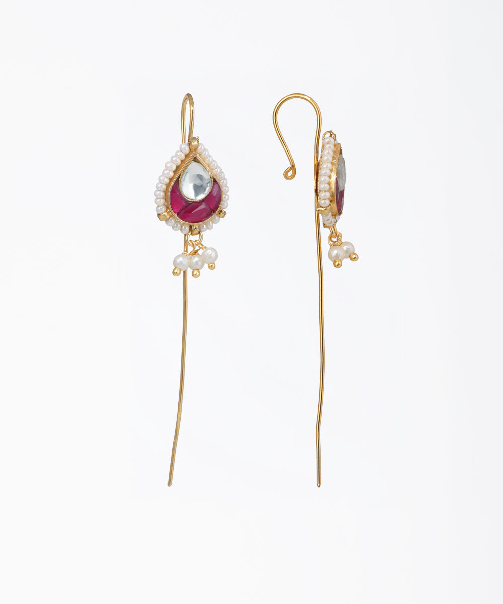 Gold earrings with red gemstones and pearl-like beads on a white background