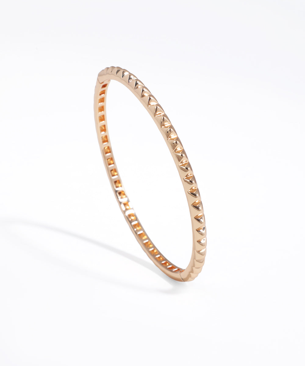 Rose gold ring with a textured band on a white background