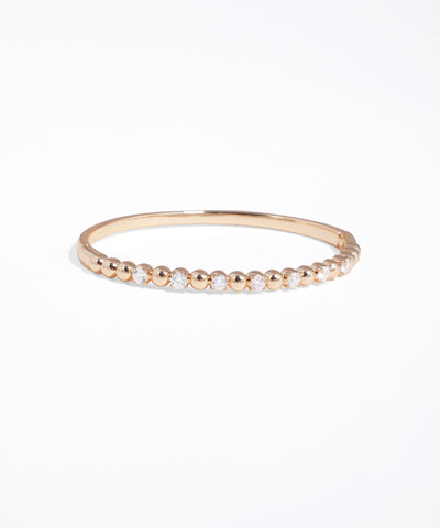 Gold bracelet with small beads on a white background
