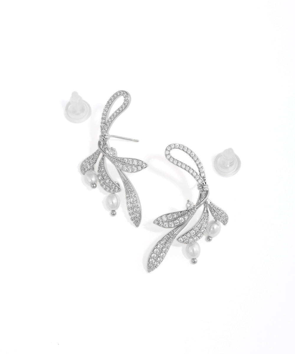 Silver leaf-shaped earrings with pearl-like stones on a white background