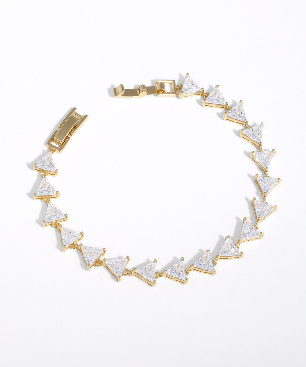 Gold-tone bracelet with a line of clear triangular cubic zirconia stones and a secure clasp.