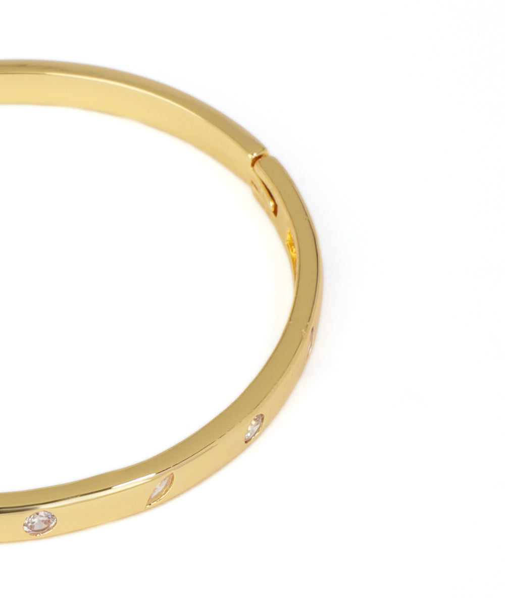 Gold bracelet with small diamonds on a white background