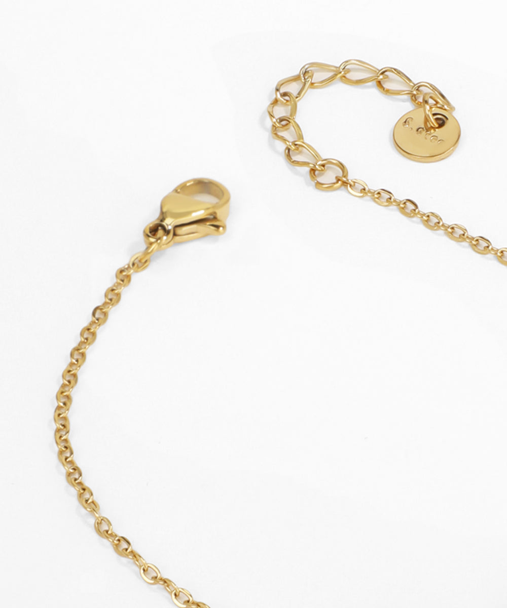 Gold bracelet with a heart-shaped clasp on a white background