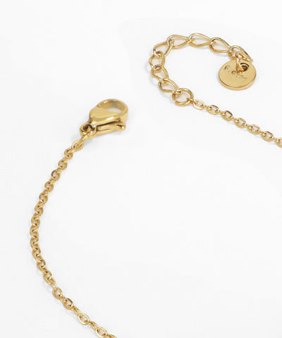 Gold bracelet with a heart-shaped clasp on a white background
