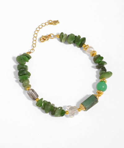 Gold-tone bracelet with mixed green glass chips, clear glass crystals, and a faux pearl accent.