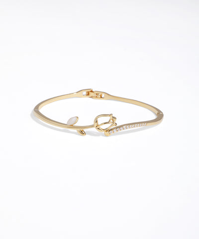 Gold bracelet with heart charm on a white background