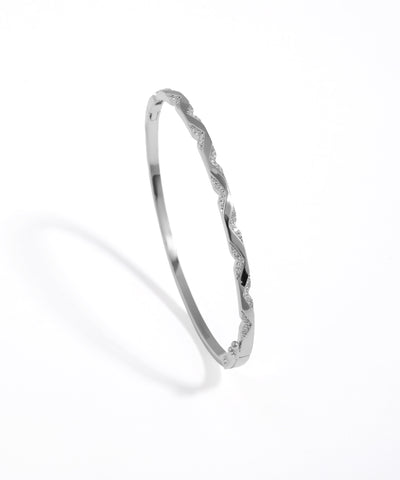 Silver bangle with twisted design on a white background