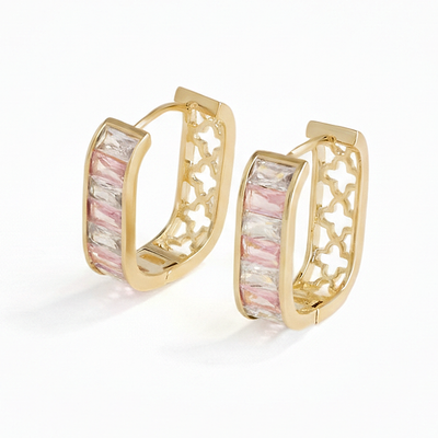 Gold hoop earrings with pink and white stone inlay on a white background