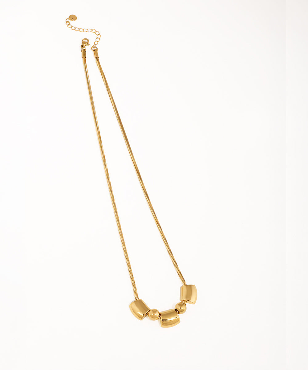 Gold-tone necklace with a smooth snake chain and three polished, minimalist geometric beads.